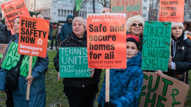 Supporters of the London Renters Union at a rally in Cavendish Square Gardens, holding signs that read 'safe and secure homes for all'.