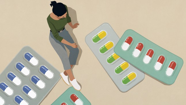 High angle view woman looking down at large medication in blister packs